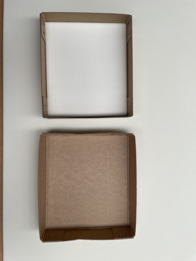 Two empty square boxes on white surface.